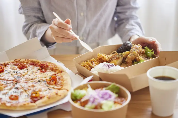 Female hand eating food delivery food