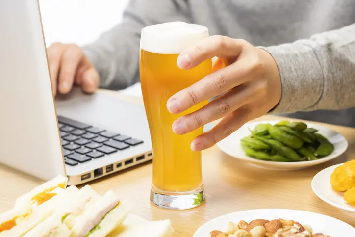 Man having an online drinking party in his room