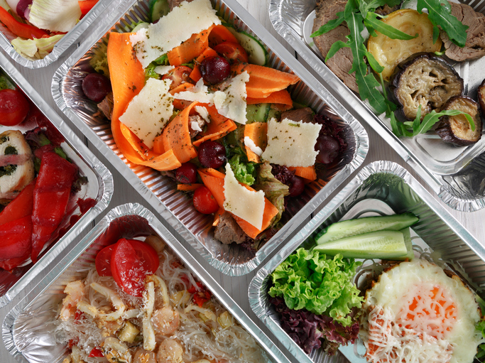 Healthy food background. Take away of natural organic food in foil boxes. Fitness nutrition, meat, rice vermicelli, vegetable salads and eggs. Top view, flat lay.