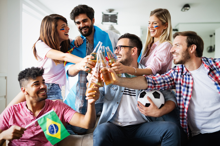 Group of friends sport fans watching soccer match toast for team