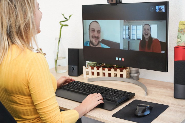 Young woman having video call party with friends using computer at home - Focus on right hand