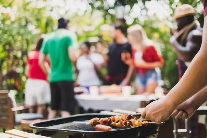 Group of deversity people having barbecue/barbeque party at home, cooking grilled meat/beef for lunch, happy friends party lifestyle concept