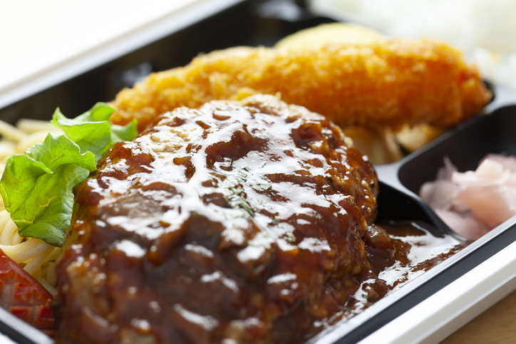 Close-up of a lunch box containing hamburger steak.