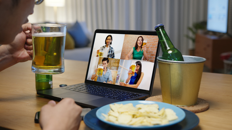Attractive young happy asian man enjoy relax night party event online celebration festive with friends at home clinking beer with glass and bottle toasting drinking via video call.